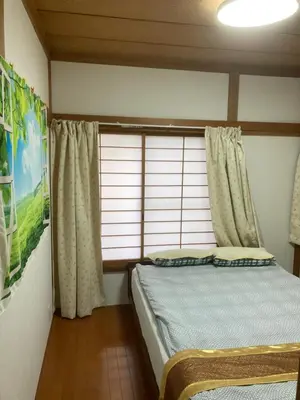 a bedroom with a bed and a window with curtains at 3-min to Station,5BR, 1LR villa near Asakusa, 95\u5e73\u7c735\u95f4\u5367\u5ba4\u4f11\u606f\u597d Stay Dream Hotel in Tokyo