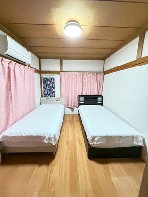two beds in a room with wooden floors at 3-min to Station,5BR, 1LR villa near Asakusa, 95\u5e73\u7c735\u95f4\u5367\u5ba4\u4f11\u606f\u597d Stay Dream Hotel in Tokyo