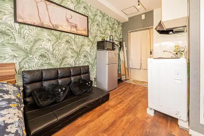 a living room with a leather couch and a refrigerator at 301\u95e8\u524d\u4ef2\u753a\u4e24\u5206\u949f\u6b65\u884c \u5168\u65b0\u5bbd\u655e\u516c\u5bd3 \u4e24\u6761\u5730\u94c1\u76f4\u8fbe\u65b0\u5bbf\u4e1c\u4eac\u4e0a\u91ce in Tokyo