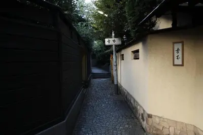an alley with a sign on the side of a building at Studio-D in Tokyo