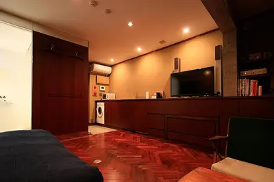 a bedroom with a bed and a flat screen tv at Studio-D in Tokyo