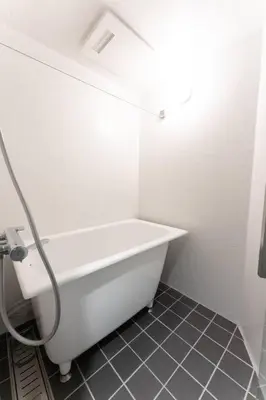 a white bath tub in a bathroom with a tile floor at Corent\u4ee3\u7530\u6a4b in Tokyo