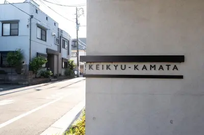 a street sign on the side of a building at unito KEIKYU-KAMATA in Tokyo