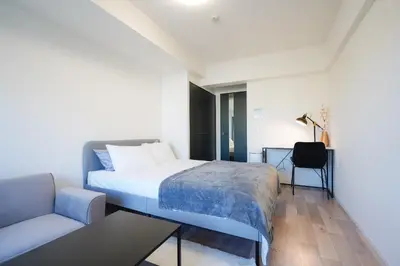 a bedroom with a bed and a couch and a table at unito KEIKYU-KAMATA in Tokyo