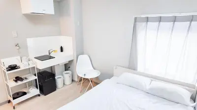 a white bedroom with a bed and a desk at 9stay\u8535\u524d in Tokyo