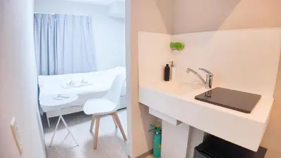 a bathroom with a white sink and a white chair at 9stay\u8535\u524d in Tokyo