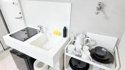 a white bathroom with a sink and a mirror at 9stay\u8535\u524d in Tokyo