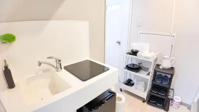 a white bathroom with a sink and a mirror at 9stay\u8535\u524d in Tokyo