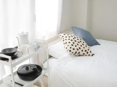 a bedroom with a white bed with a black and white pillow at 9stay\u8535\u524d in Tokyo