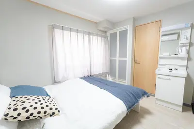 a bedroom with a white bed and a window at 9stay\u8535\u524d in Tokyo