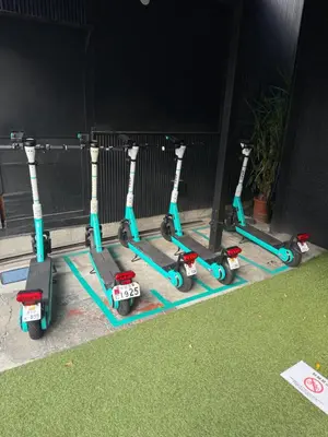 a row of scooters lined up against a building at D\u65c5\u9928\u3000Dryokan in Tokyo