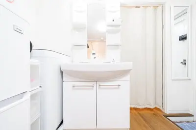 a white bathroom with a sink and a mirror at \u5927\u585a\u99c51\u5206\uff01\u6c60\u888b\u30a8\u30ea\u30a2\uff01\u30b0\u30eb\u30fc\u30d7\u65c5\u884c\u306b\u6700\u9069 in Tokyo