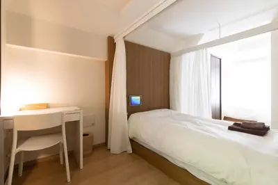 a bedroom with a bed and a desk and a window at EMILIO Nishi-Shinjuku Room 401 - Vacation STAY 89570v in Tokyo