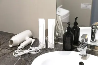a bathroom counter with a sink with a phone and bottles at SLEEPLAB THE STAY Nishi-Shinjuku - Vacation STAY 89579v in Tokyo