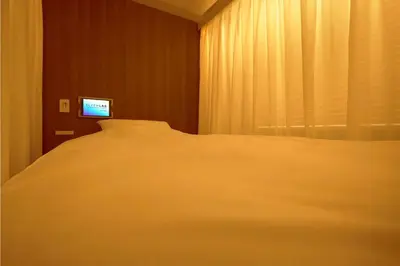 a bedroom with a white bed and a television at SLEEPLAB THE STAY Nishi-Shinjuku - Vacation STAY 89579v in Tokyo