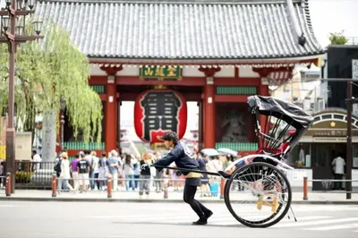 a woman pushing a bike in front of a building at 401 Oshiage sta 3mins walk! Wi-Fi Elevator 4pax in Tokyo