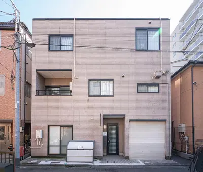 a large brick building with a garage at ZAITO Tokyo Luna Lane Inn \u83ca\u5ddd\u99c5\u304b\u3089\u5f92\u6b695\u5206 in Tokyo