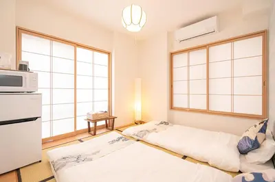 a living room with two beds and a microwave at ZAITO Tokyo Luna Lane Inn \u83ca\u5ddd\u99c5\u304b\u3089\u5f92\u6b695\u5206 in Tokyo