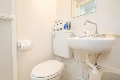 a white bathroom with a toilet and a sink at ZAITO Tokyo Luna Lane Inn \u83ca\u5ddd\u99c5\u304b\u3089\u5f92\u6b695\u5206 in Tokyo