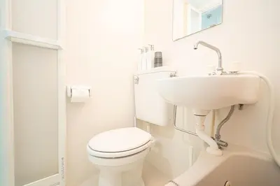 a white bathroom with a toilet and a sink at ZAITO Tokyo Luna Lane Inn \u83ca\u5ddd\u99c5\u304b\u3089\u5f92\u6b695\u5206 in Tokyo