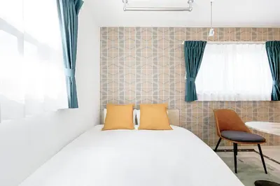 a bedroom with a bed with two orange pillows at J'sコート落合 in Tokyo