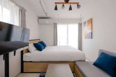 a bedroom with a bed and a tv and a couch at J'sコート落合 in Tokyo