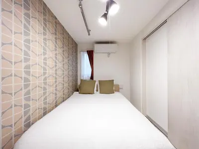 a bedroom with a bed with two chairs in it at J'sコート落合 in Tokyo