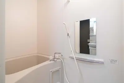 a white bathroom with a bath tub and a mirror at \u30ab\u30fc\u30b5\u30d6\u30e9\u30f3 in Tokyo