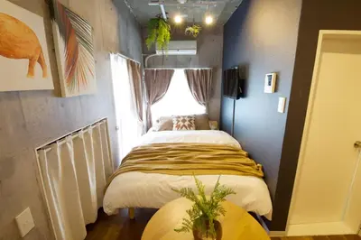 two beds in a small room with a window at EDIFICE SHIBUYA301 in Tokyo