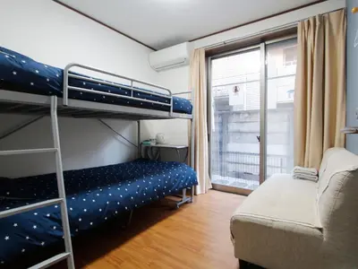 a bedroom with two bunk beds and a couch at \u548c\u8cb4\u30d3\u30eb in Tokyo