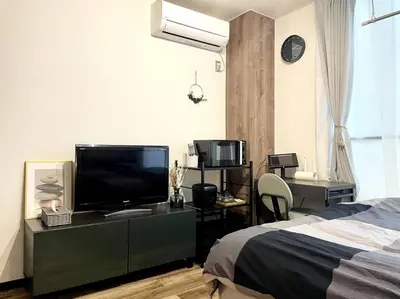 a bedroom with a bed and a flat screen tv at The Hotel SPACE \u4e0b\u5317\u6ca2 in Tokyo