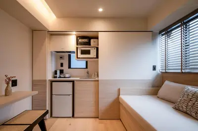 a living room with a couch and a kitchen at LiveGRACE Hotel Azabu \u9ebb\u5e03\u829d\u516c\u5712 in Tokyo