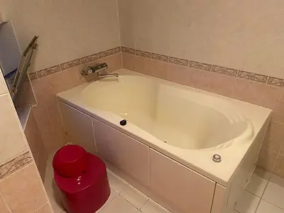 a white tub in a bathroom with a red trash can at \u30db\u30c6\u30eb\u30d5\u30a9\u30fc\u30e9\u30e0 in Tokyo