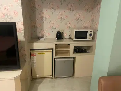 a small kitchen with a microwave and a refrigerator at \u30db\u30c6\u30eb\u30d5\u30a9\u30fc\u30e9\u30e0 in Tokyo