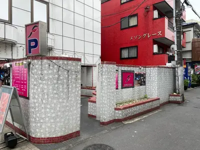 a red building with white tiles on the side of a street at \u30db\u30c6\u30eb\u30d5\u30a9\u30fc\u30e9\u30e0 in Tokyo
