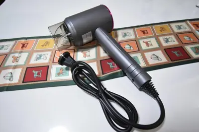 a black blow dryer sitting on top of a table at \u30a2\u30f3\u30c9\u30b9\u30c6\u30a4\u4e2d\u91ce5\u4e01\u76ee203 in Tokyo