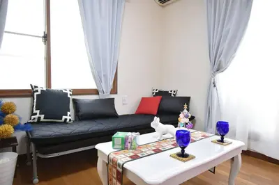 a living room with a couch and a table at \u30a2\u30f3\u30c9\u30b9\u30c6\u30a4\u4e2d\u91ce5\u4e01\u76ee203 in Tokyo