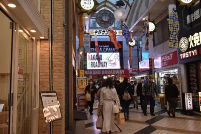 a group of people walking through a shopping mall at \u30a2\u30f3\u30c9\u30b9\u30c6\u30a4\u4e2d\u91ce5\u4e01\u76ee203 in Tokyo