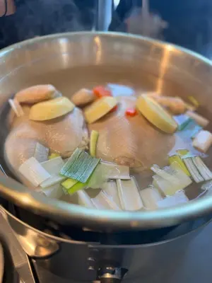 a pan filled with soup with vegetables in it at Hotel RIO\u65b0\u5bbf in Tokyo