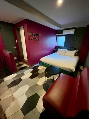 a room with a bed and a chair in it at Hotel RIO\u65b0\u5bbf in Tokyo