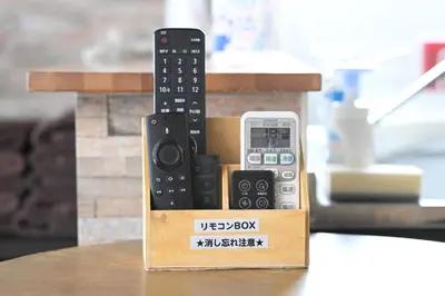 a box with two remote controls and a cell phone at AIC\u6c60\u888b502 in Tokyo