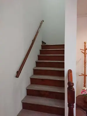 a stairway with a wooden rail and brown stairs at Urban Residence Ikebukuro East in Tokyo