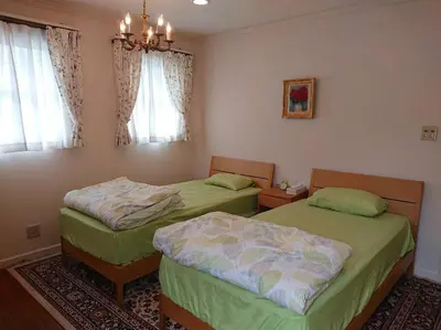 a bedroom with two beds and a chandelier at Urban Residence Ikebukuro East in Tokyo