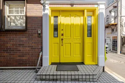 a yellow door on the side of a building at Urban Residence Ikebukuro East in Tokyo