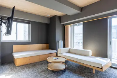 a room with two beds and a table at HOTEL TOMOS ASAKUSA in Tokyo