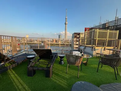 a balcony with chairs and a table on the grass at HOTEL TOMOS ASAKUSA in Tokyo