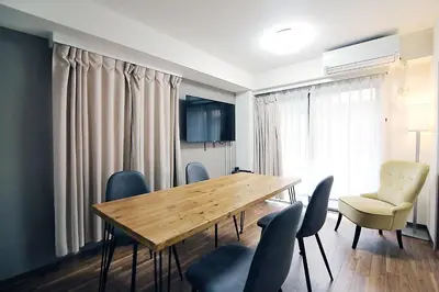 a dining room with a wooden table and chairs at EMA House 4P Free Wifi! in Tokyo
