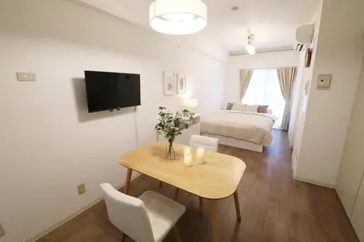 a living room with a table and a bed at Vermidor Ebisu302 in Tokyo