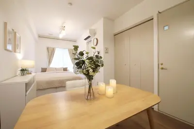 a room with a table with a vase of flowers at Vermidor Ebisu302 in Tokyo