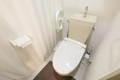 a white toilet in a bathroom with a roll of toilet paper at Vermidor Ebisu302 in Tokyo